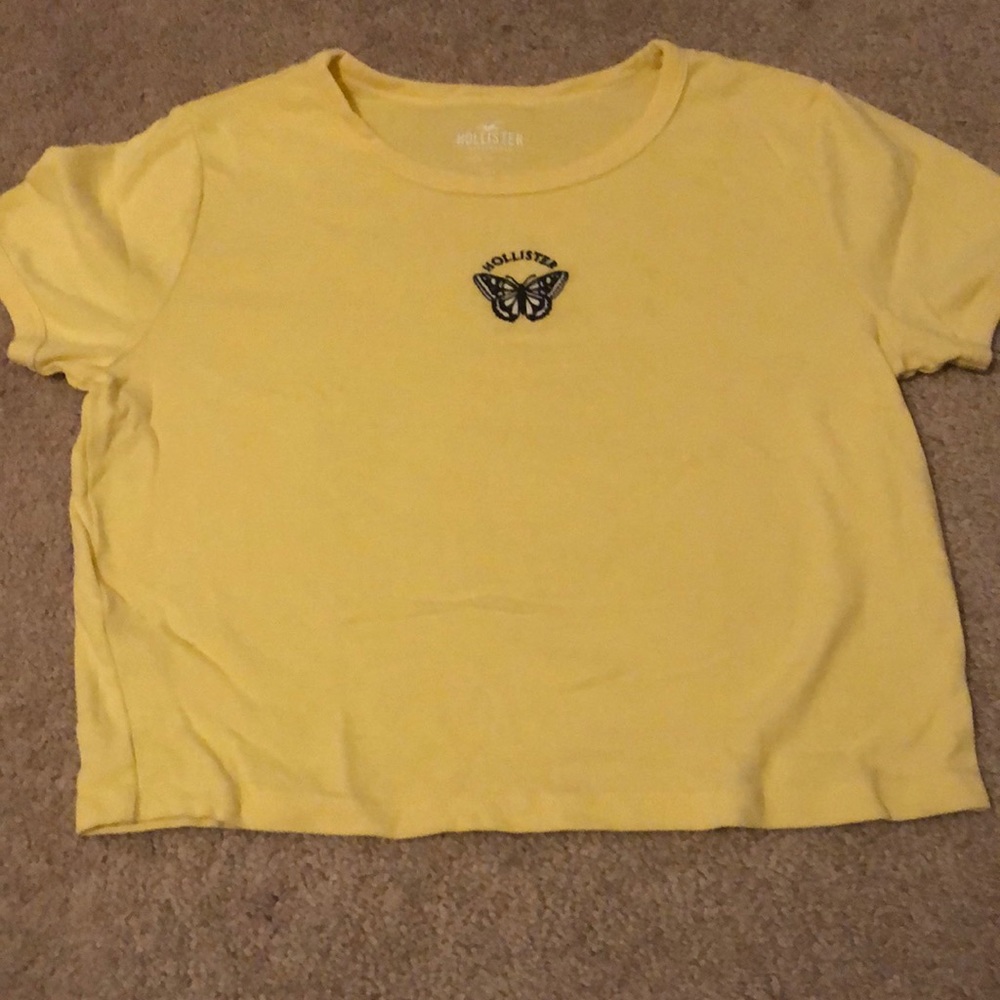 A light yellow crop top with a stitched butterfly